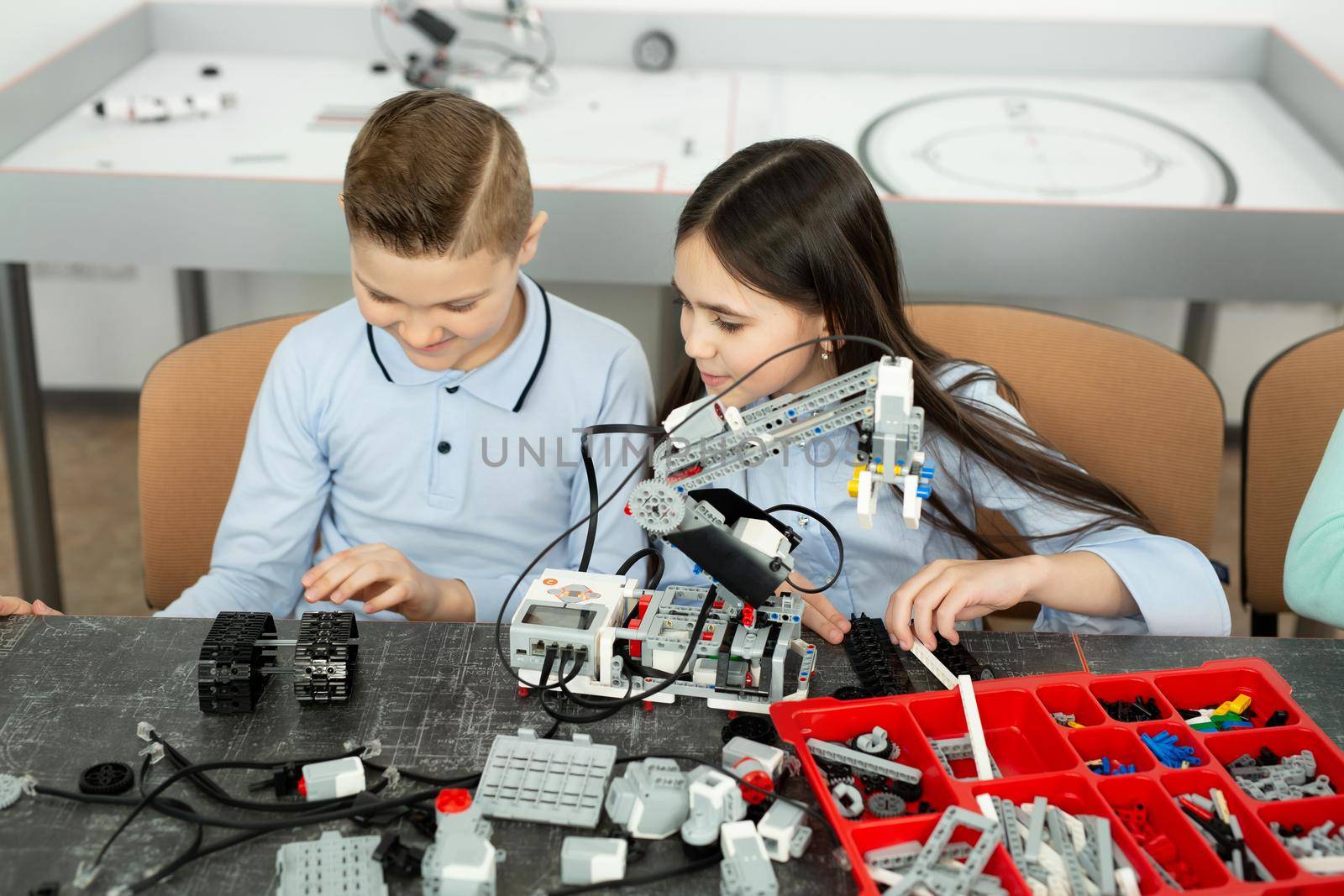 Group of children are playing with robots assembled from plastic parts.