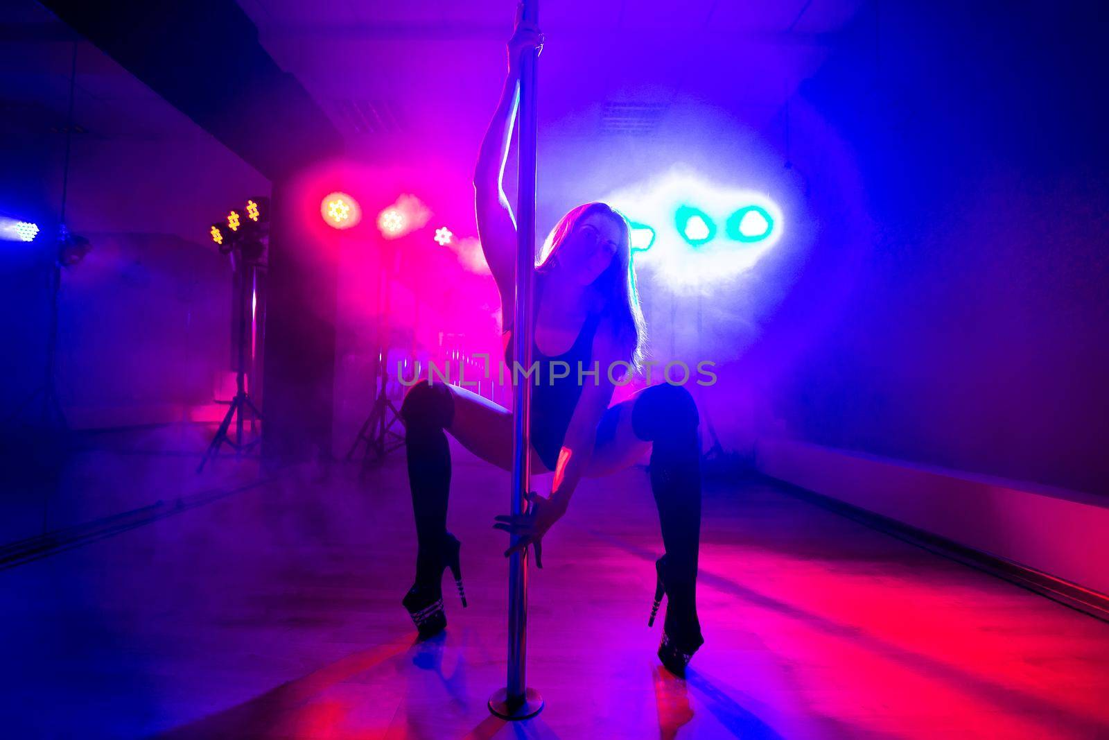 Attractive young sexy female pole dancer performs. by StudioPeace