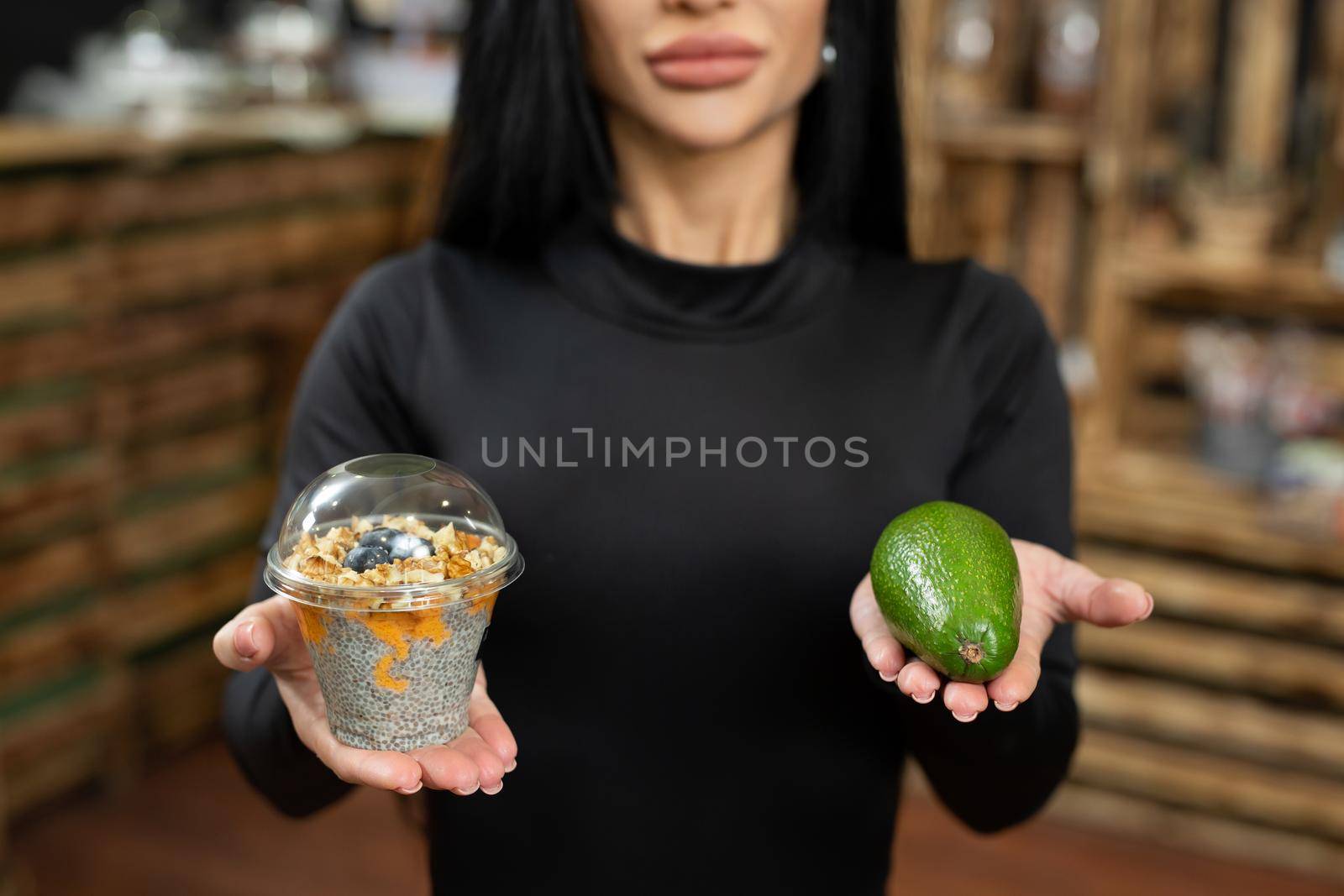 A woman chooses between a sweet dessert and a healthy avocado. The concept of diabetes. Diet by StudioPeace