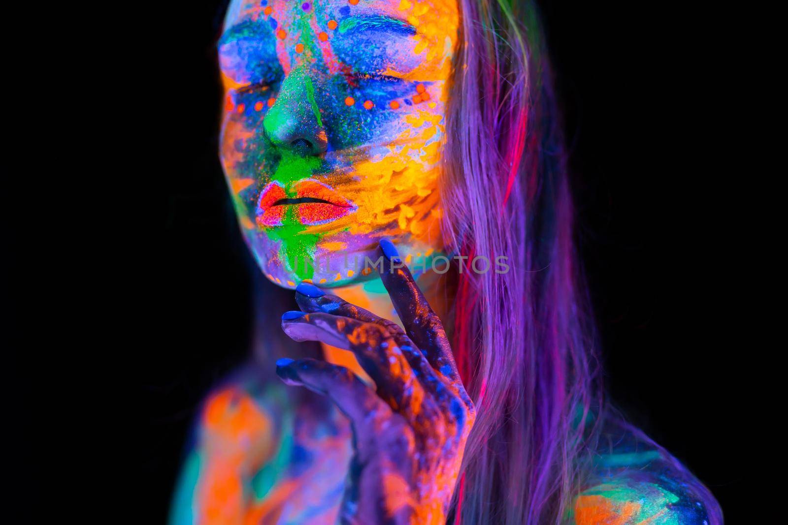 Beautiful young woman in neon light. Portrait of a model with fluorescent makeup posing in UV light with colorful makeup. by StudioPeace