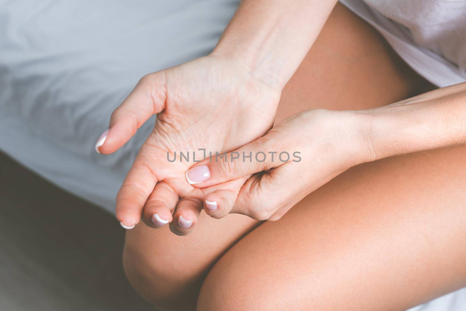 Woman suffering from hand pain and finger pain after sleep. Hand numbness or limb numbness. Massaging painful hand by DariaKulkova