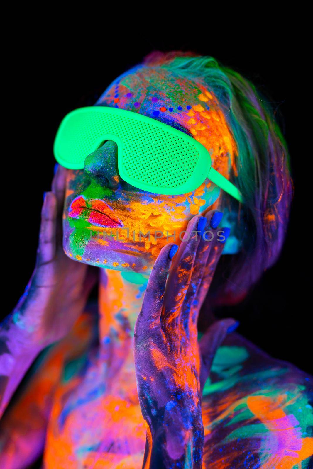 Beautiful model woman wearing glasses with colorful bright fluorescent makeup in neon light, nightclub disco by StudioPeace