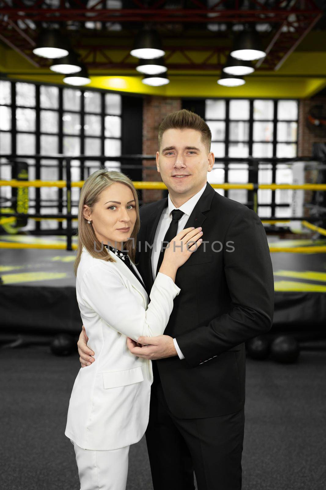 Fellow male and female businessmen in suits pose against the backdrop of a boxing ring by StudioPeace