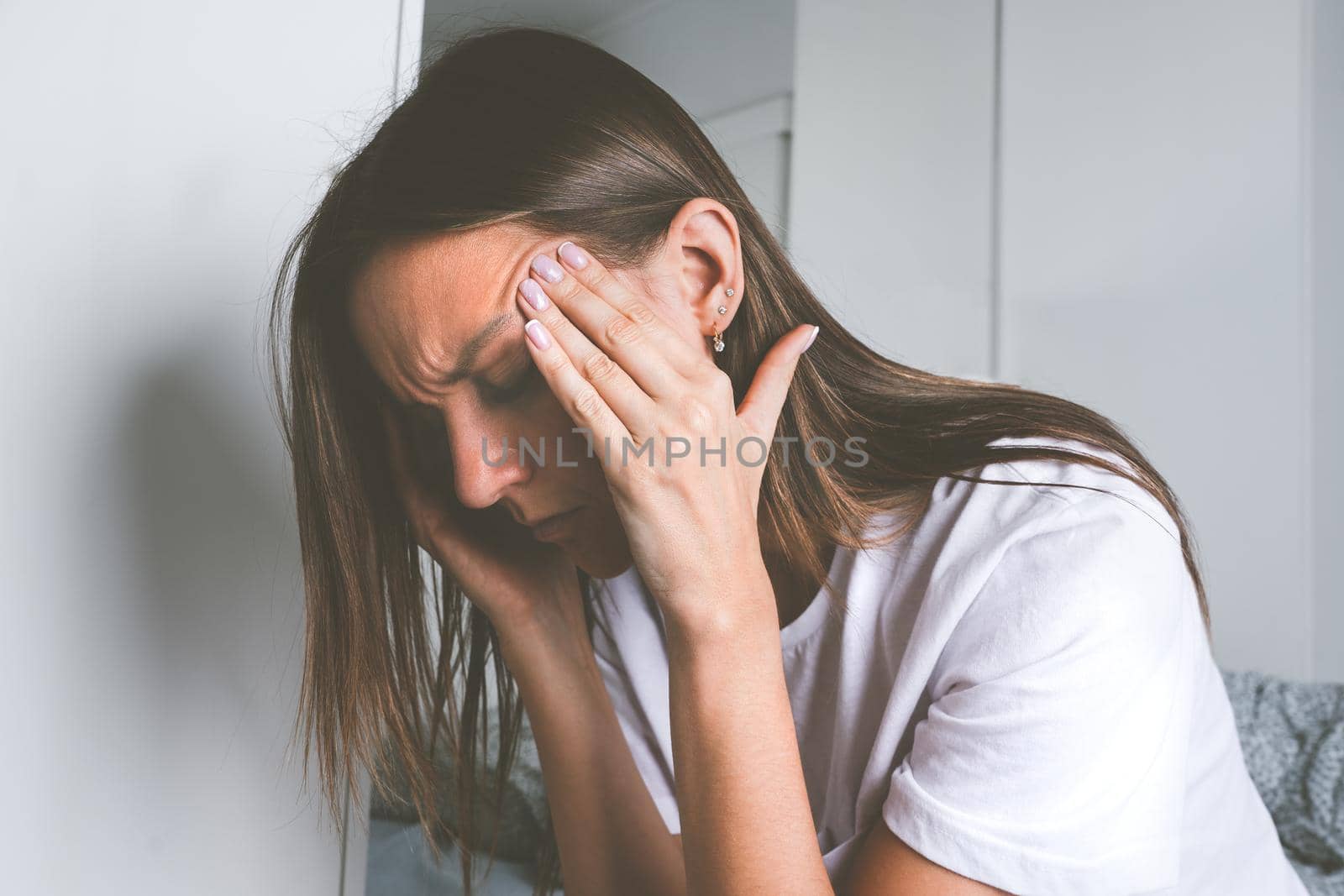 Young woman touching her temples and suffering from head pain, headache or migraine after waking up. High quality photo