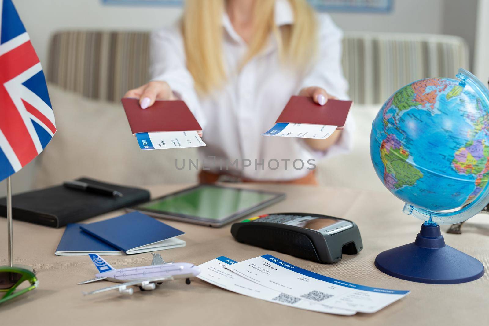 A close-up of a passport with tickets in the hands of a female tour operator in the office.