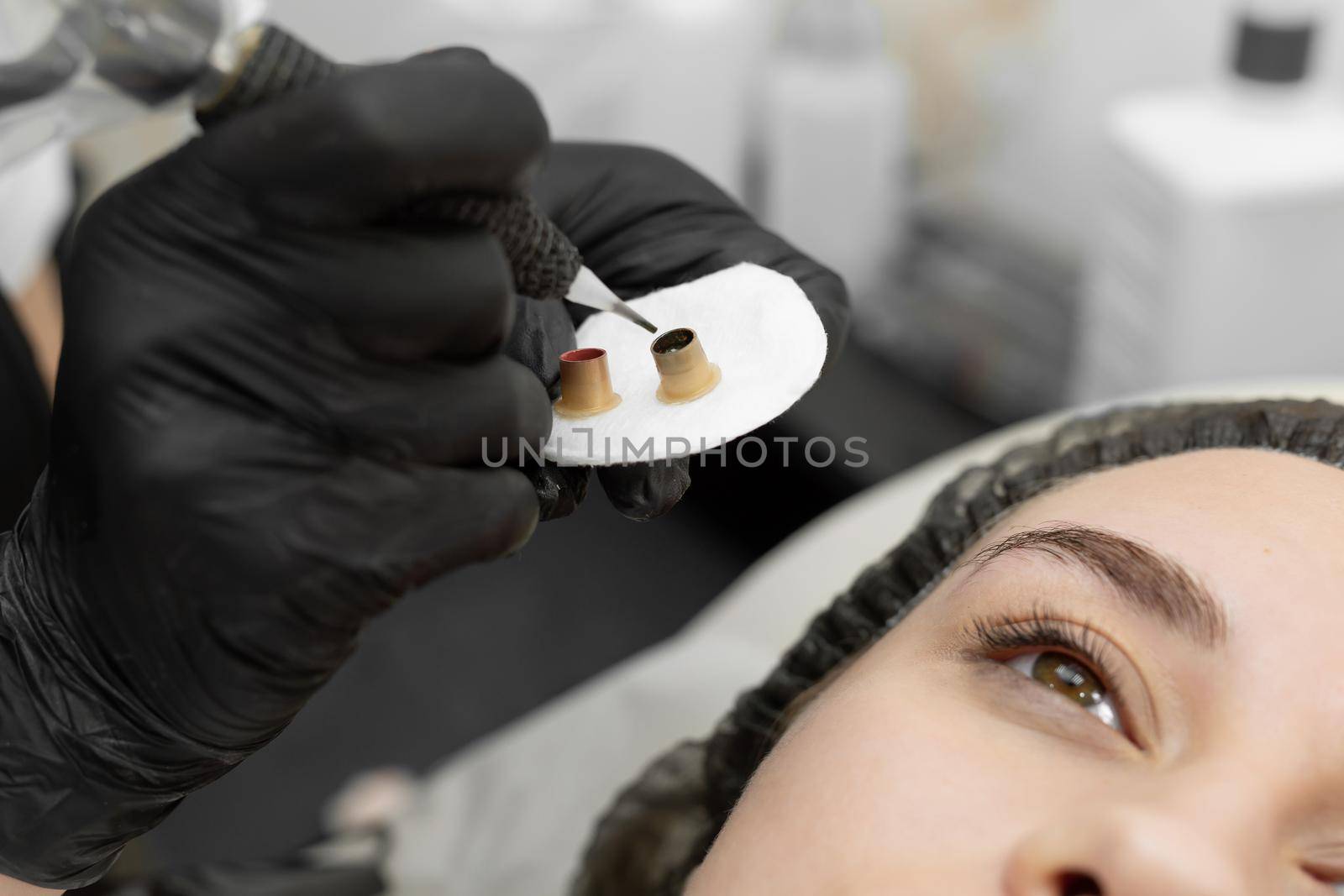Permanent eyebrow makeup procedure, eyebrow tattooing. The master types paint in the tattoo machine by StudioPeace