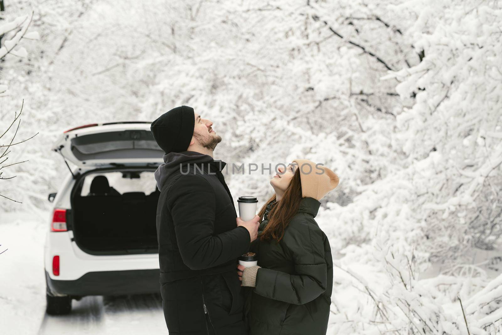Lovely couple in a winter forest on the background of a car by StudioPeace