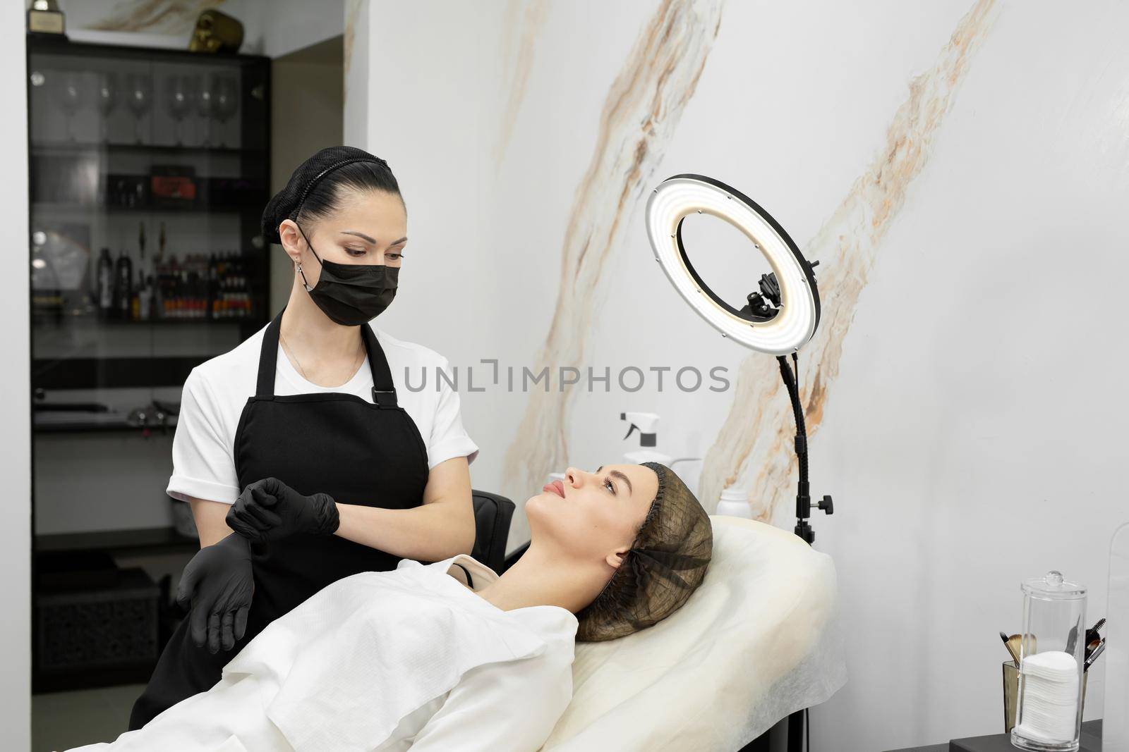 Cosmetologist puts on gloves before starting work. Permanent lip makeup by StudioPeace