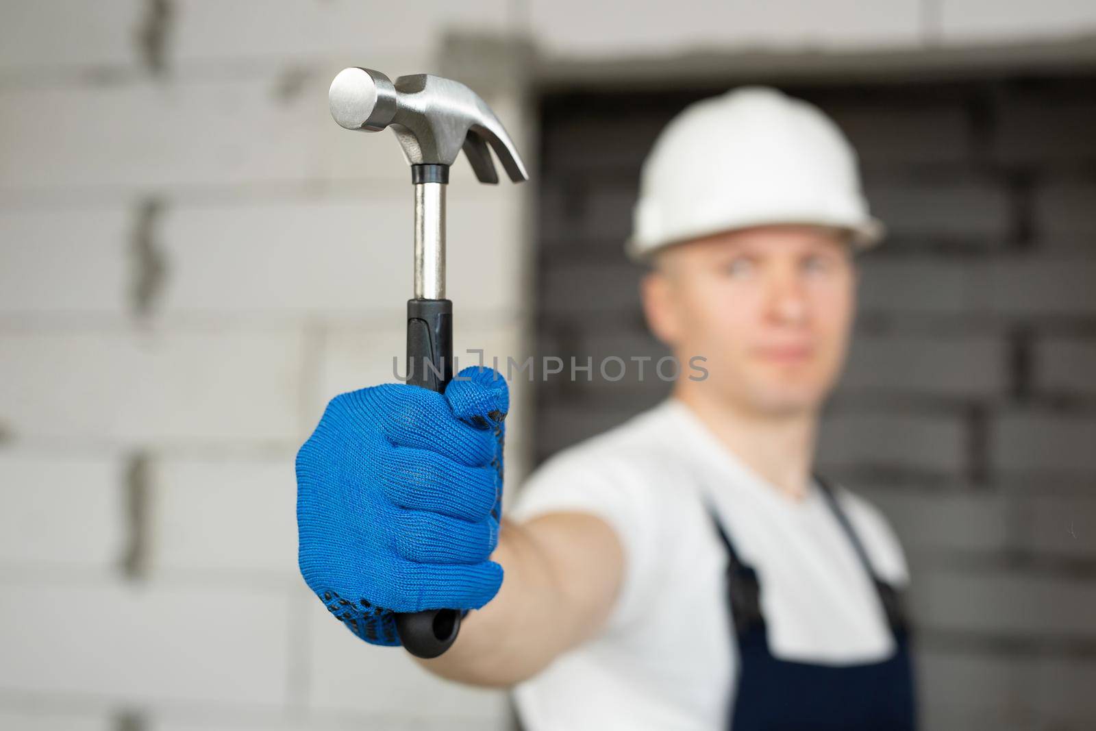 Male construction worker wearing a helmet with a hammer