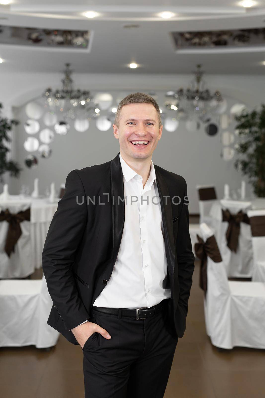 Young cheerful man in a suit in a restaurant by StudioPeace