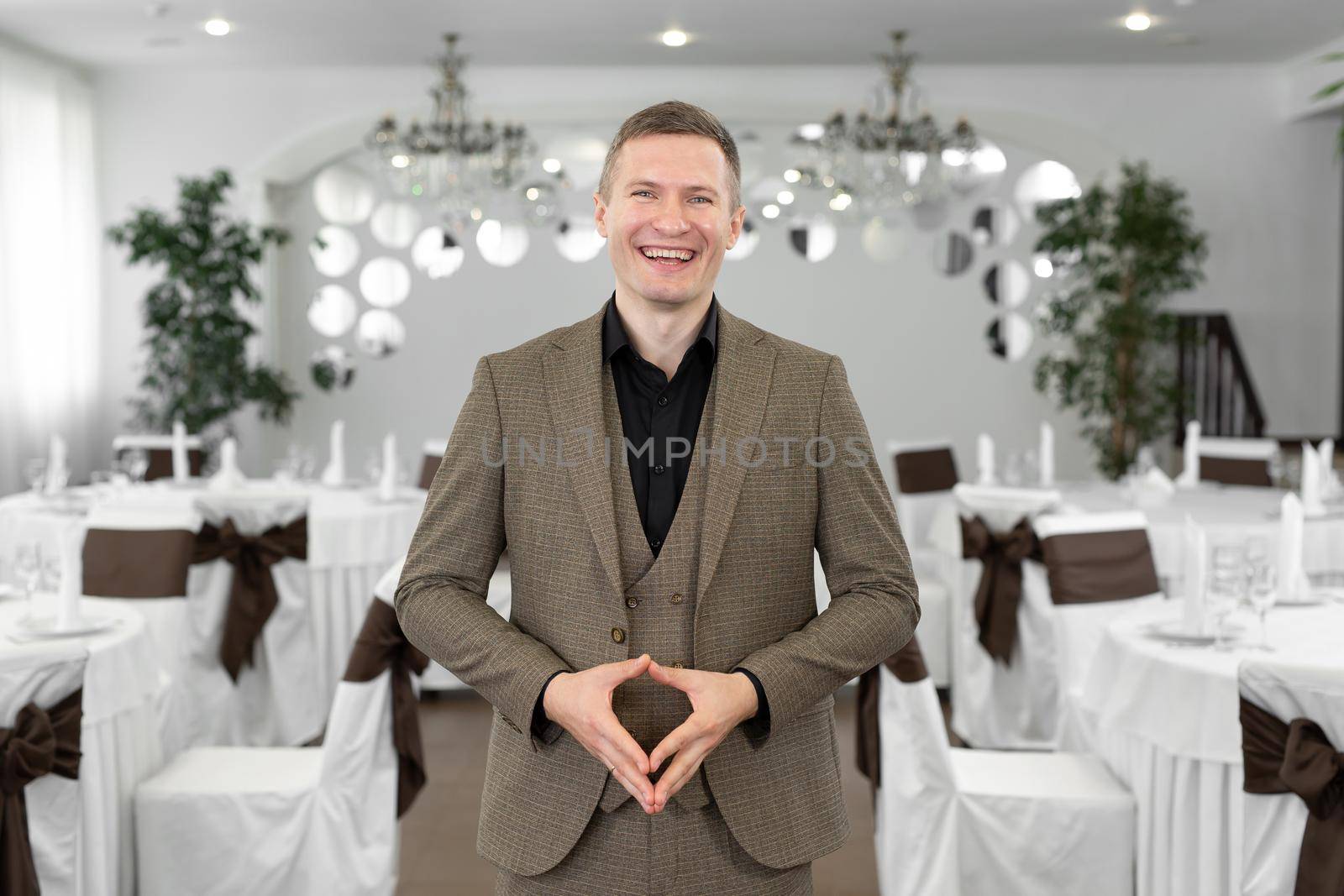 Young cheerful man in a suit in a restaurant by StudioPeace