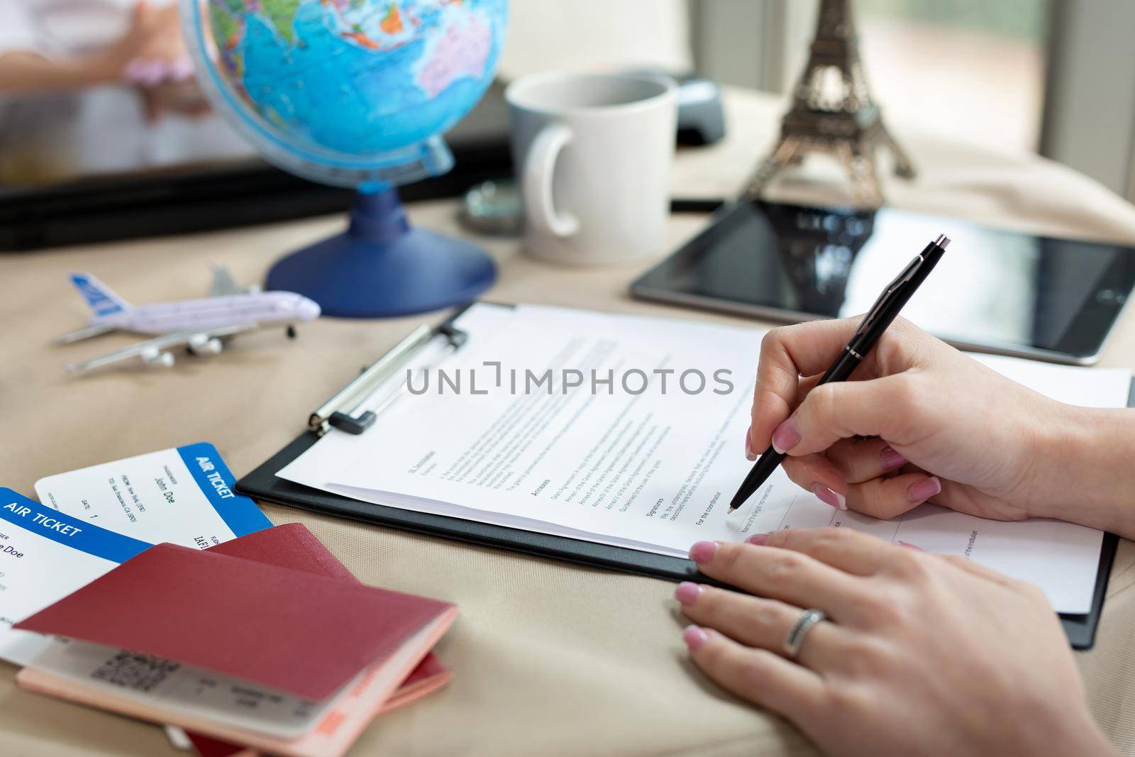 A female travel agent in the office signs a contract, close-up by StudioPeace