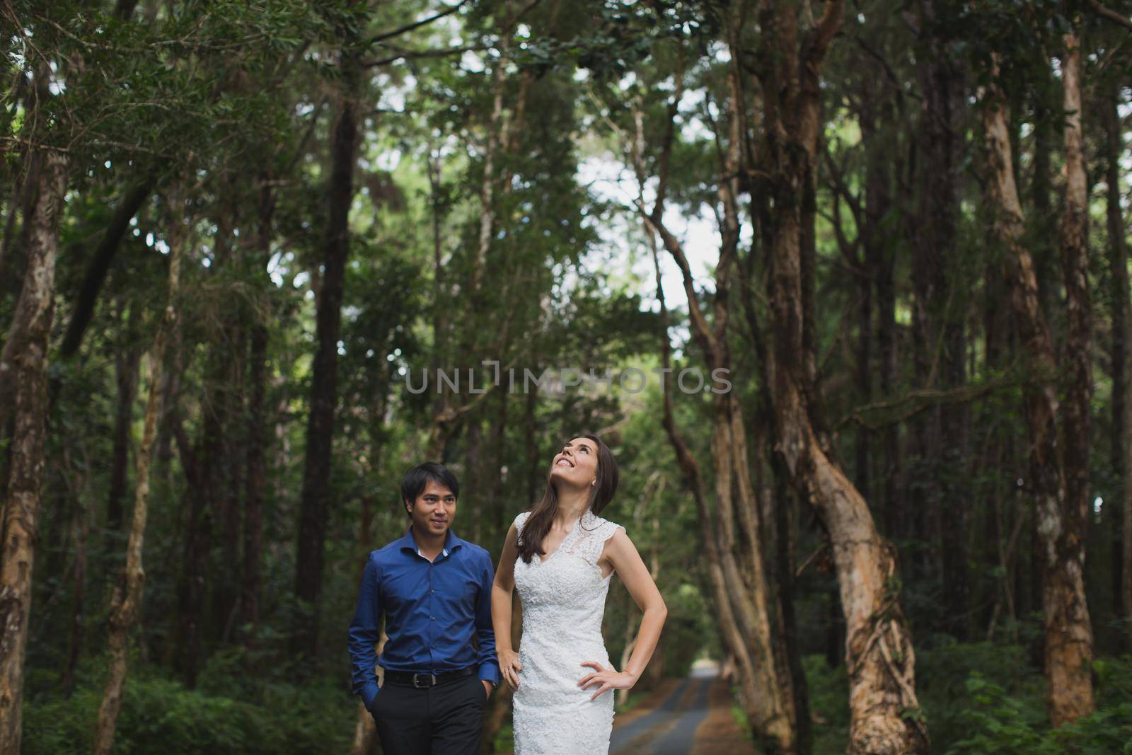 Walking the young bride and groom in the woods. by StudioPeace