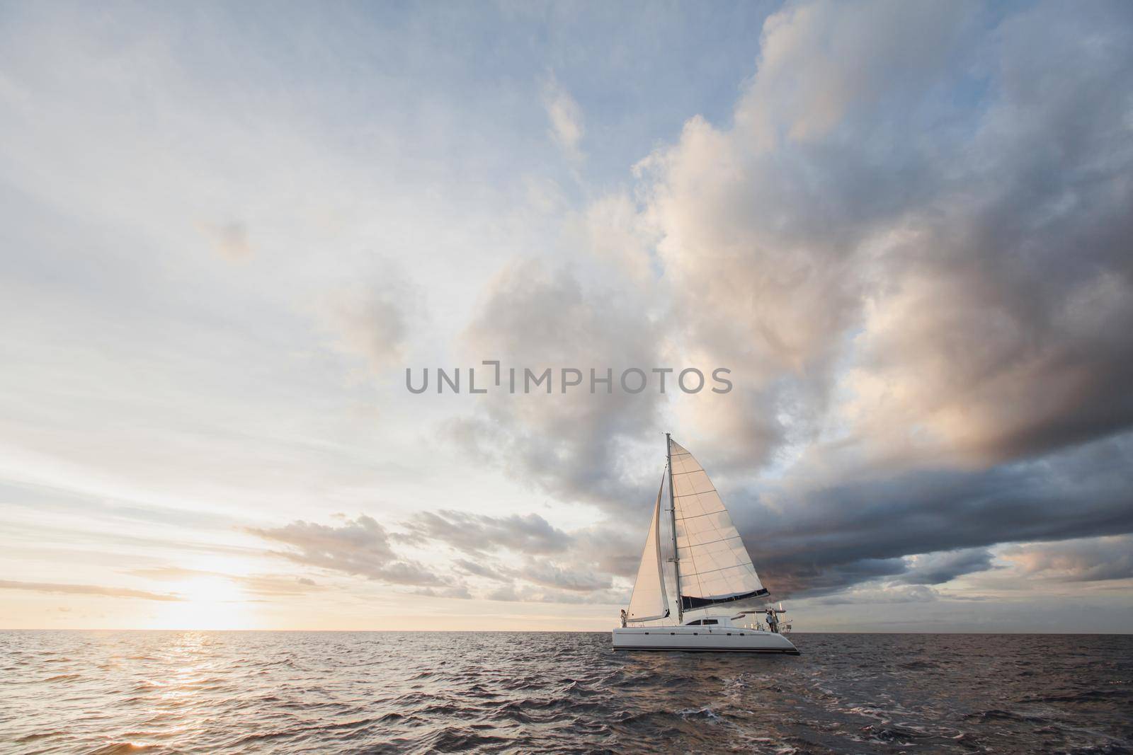 white yacht with sail set goes along the island on a hot day. blue sea, blue sky. on board a young couple in love. the bride and groom. wedding boat trip. by StudioPeace