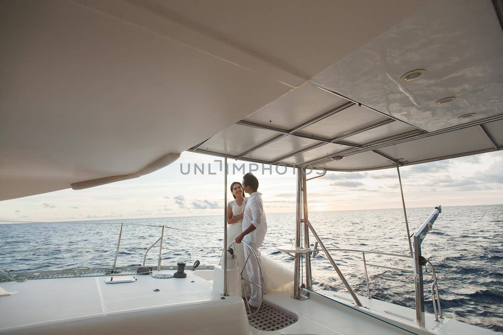 Just married couple on yacht. Happy bride and groom. by StudioPeace