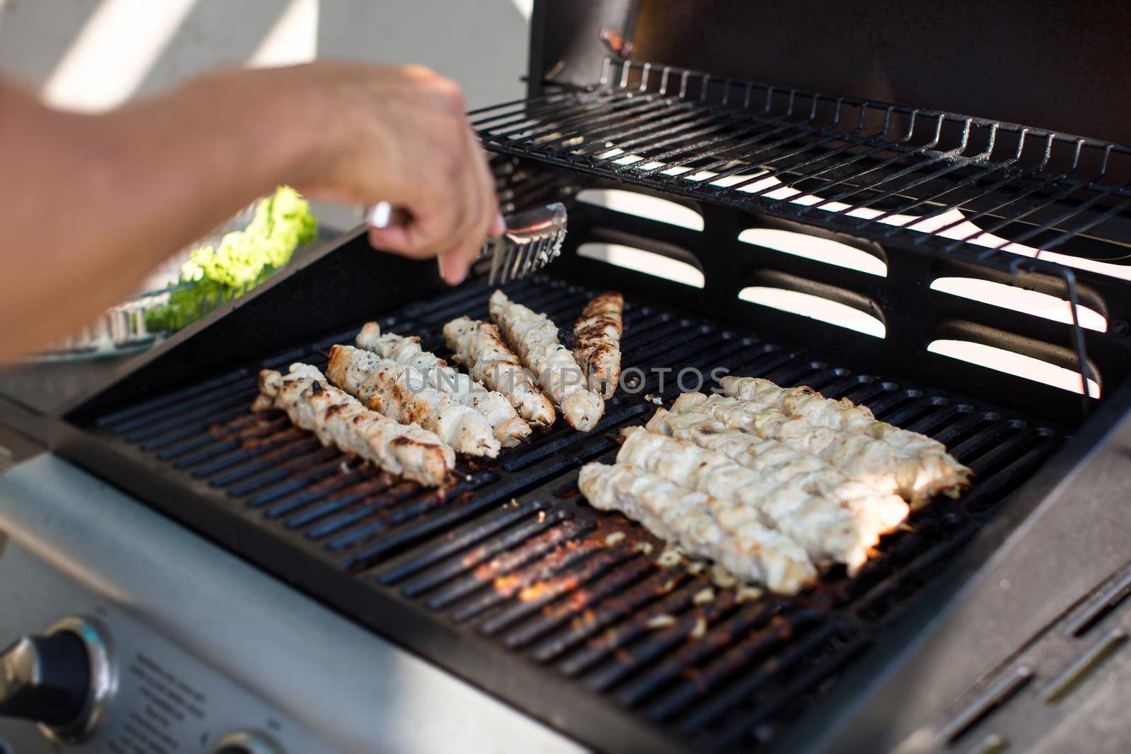 A man is preparing an outdoor barbecue.