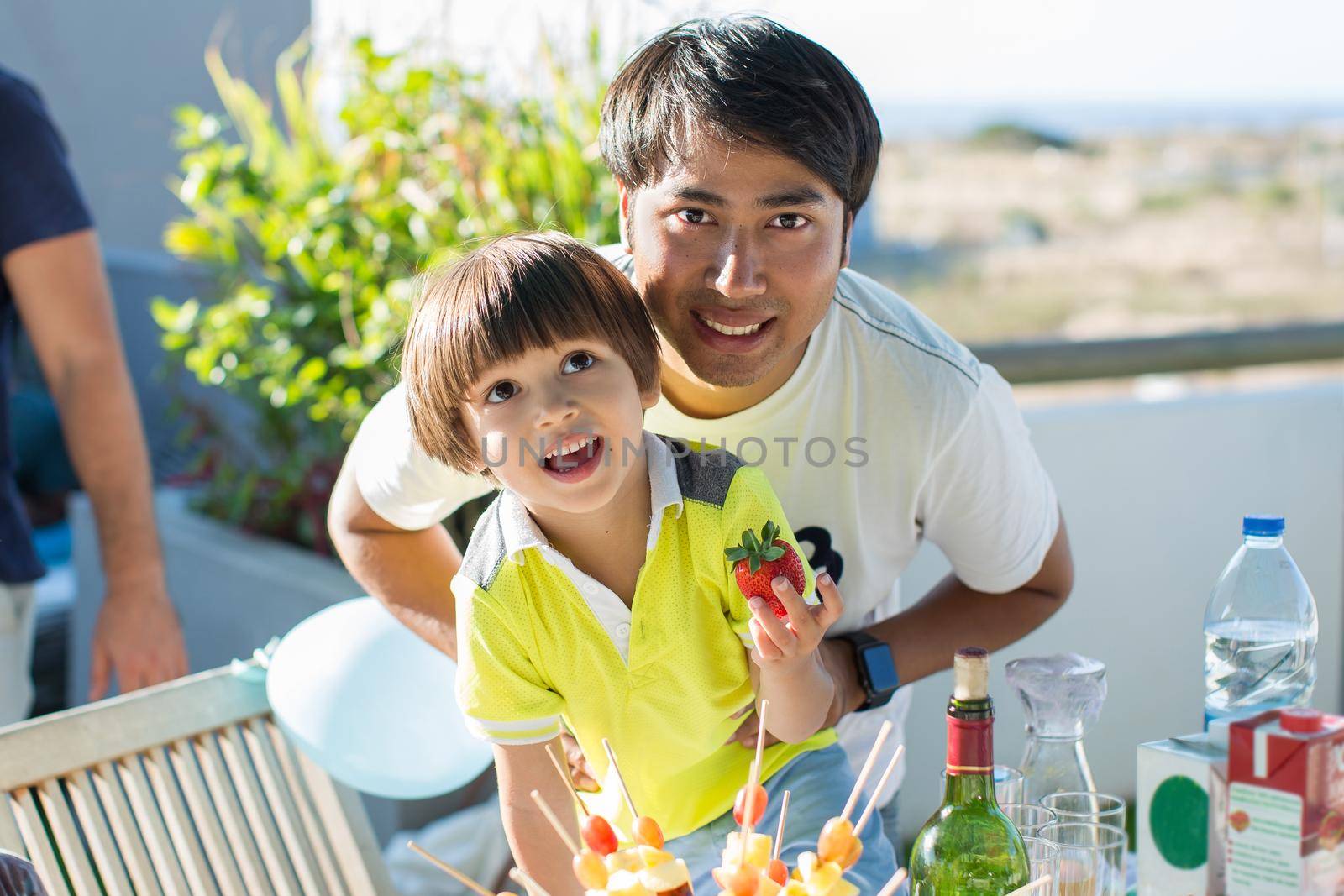 Portrait of a father and son during a family buffet by StudioPeace