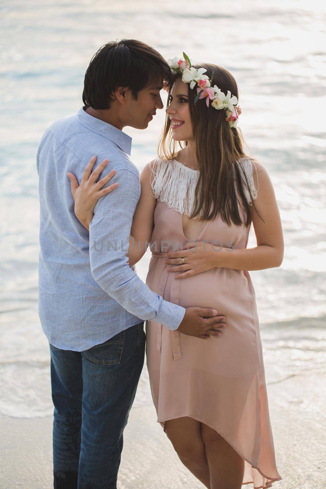 Beautiful pregnant girl and man on the beach. by StudioPeace