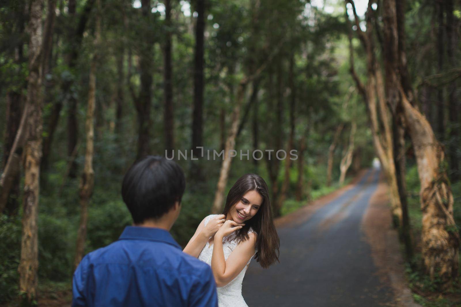 Walking the young bride and groom in the woods. by StudioPeace