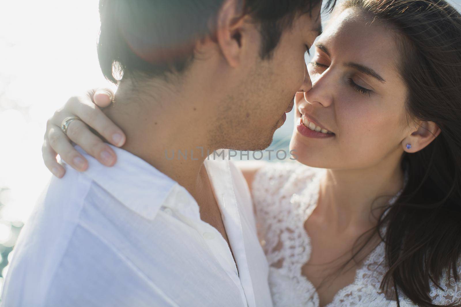Beautiful wedding couple bride and groom on yacht at wedding day outdoors in the sea. Happy marriage couple kissing on boat in ocean. Stylish Marine wedding by StudioPeace