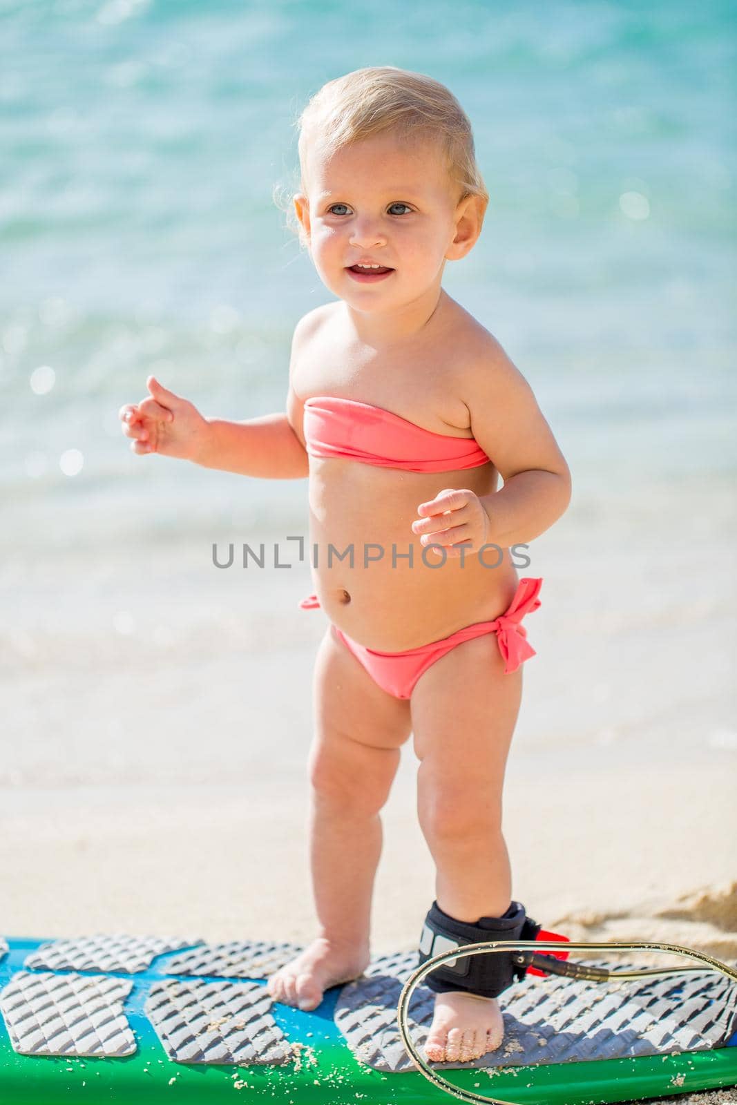 A little girl learns to surf on the ocean