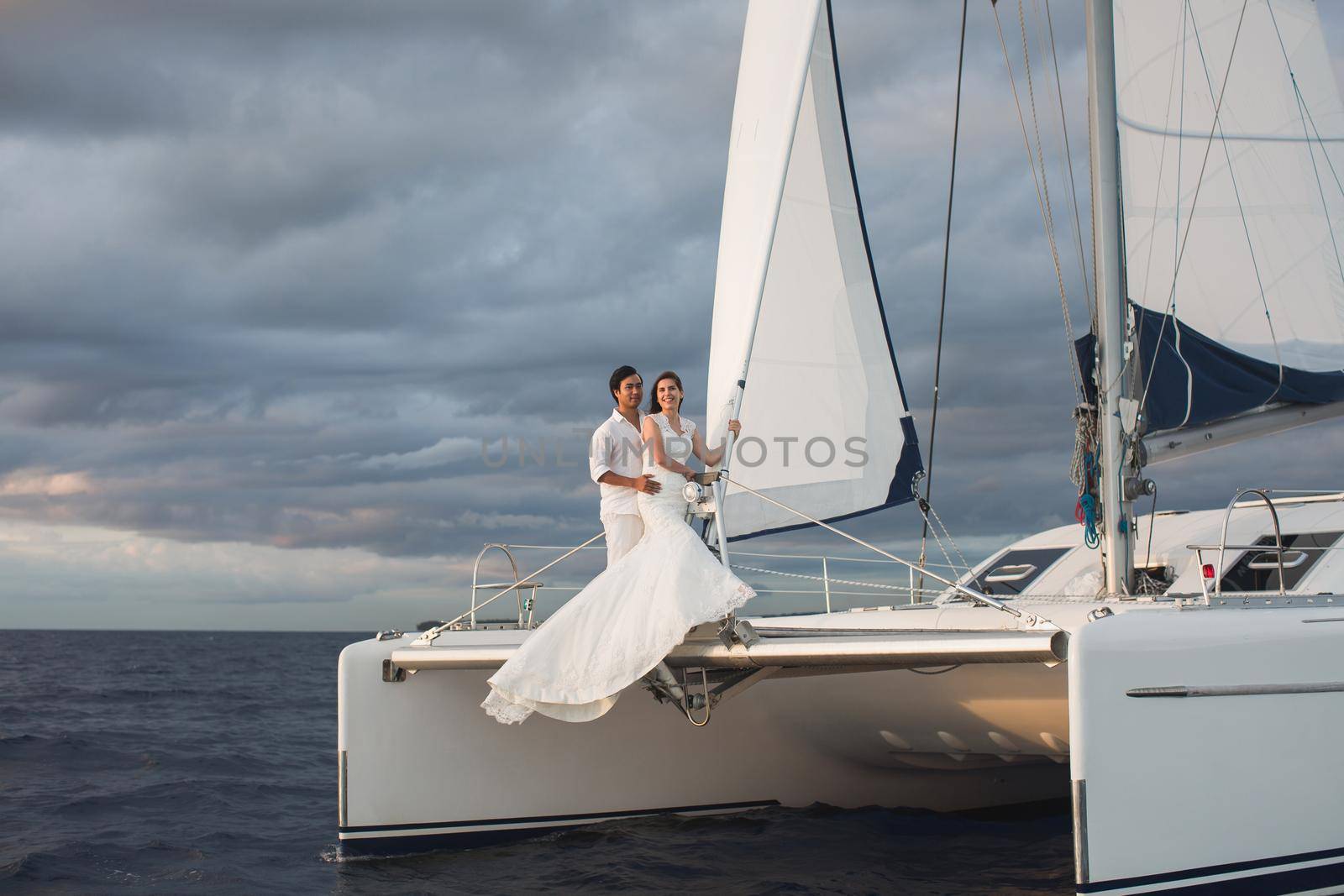 Wedding couple is hugging on a yacht. Beauty bride with groom by StudioPeace
