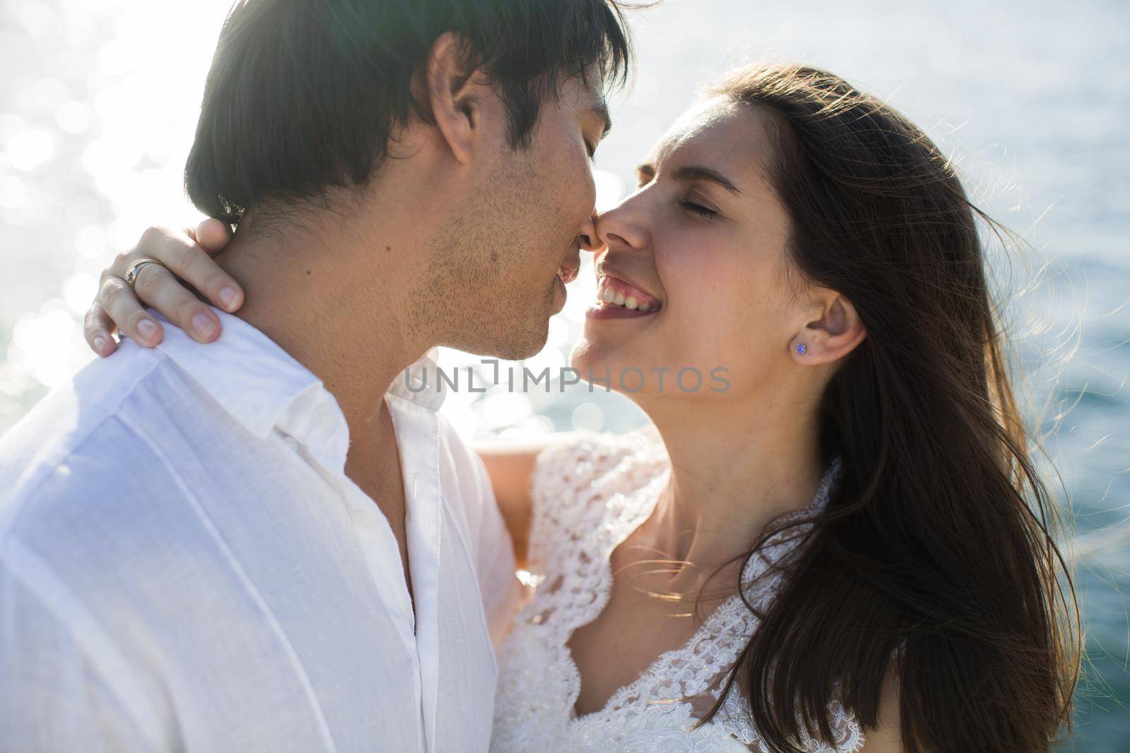 Beautiful wedding couple bride and groom on yacht at wedding day outdoors in the sea. Happy marriage couple kissing on boat in ocean. Stylish Marine wedding by StudioPeace