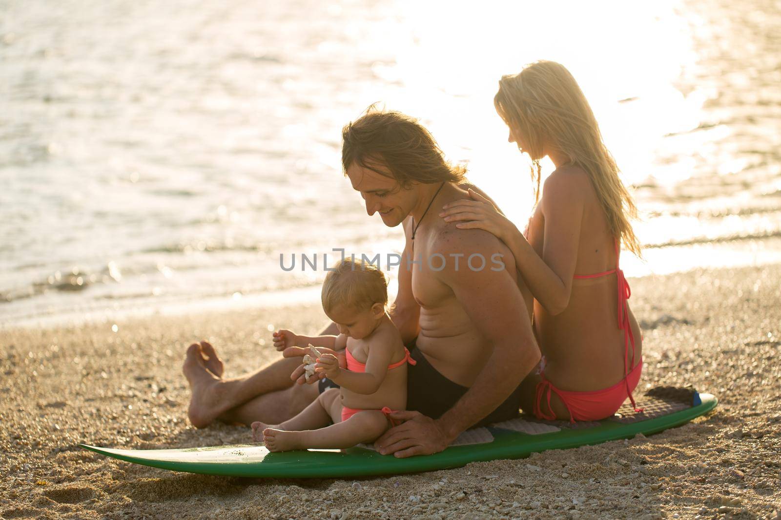 surfing. happy family sits on the surfboard. concept about family, sport and fun