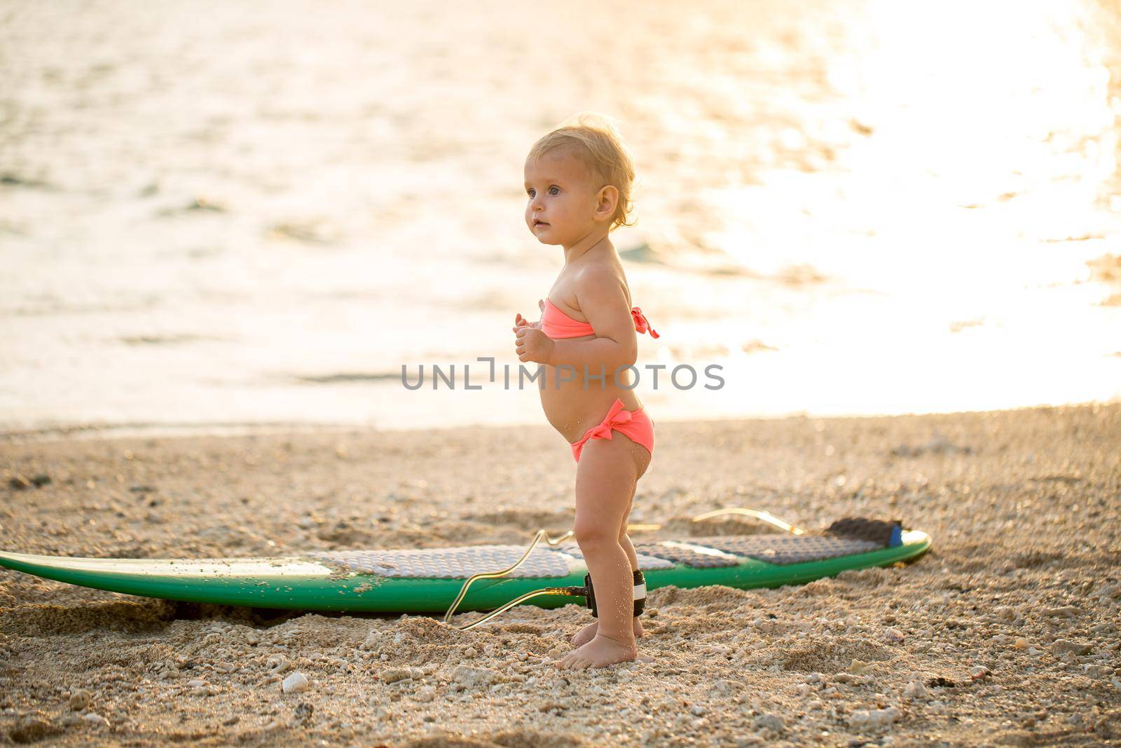 A little girl learns to surf on the ocean