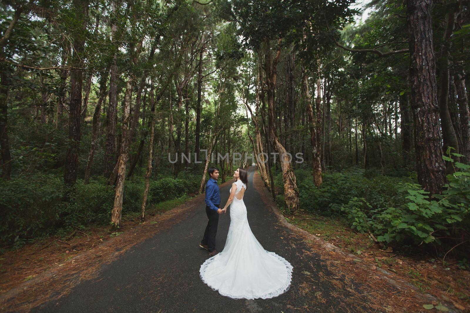 Walking the young bride and groom in the woods. by StudioPeace