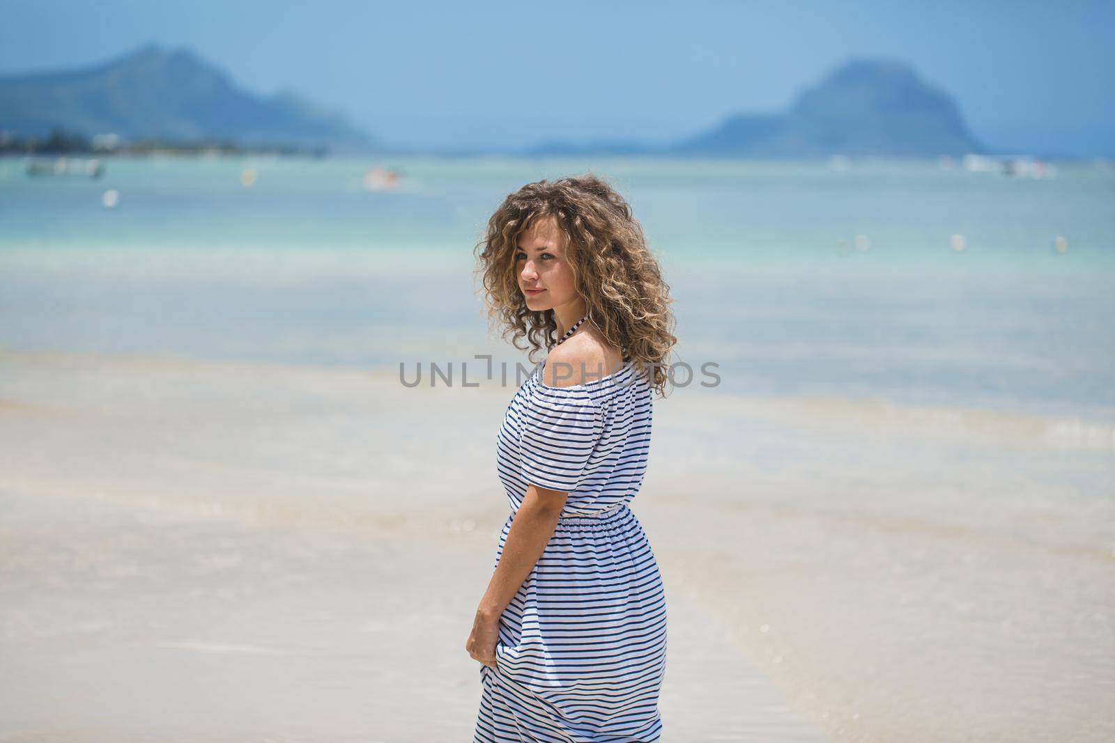 Beautiful girl in the Indian ocean with mountains in the background.