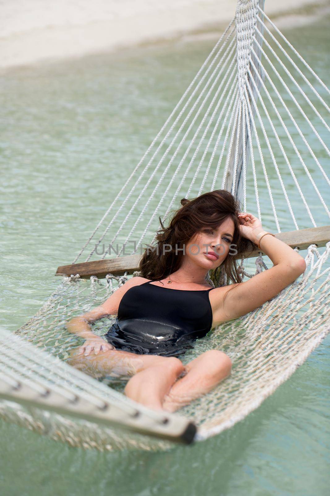 Woman in hammock on tropical beach at island