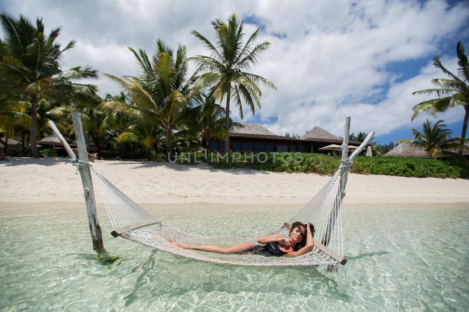 Woman in hammock on tropical beach at island