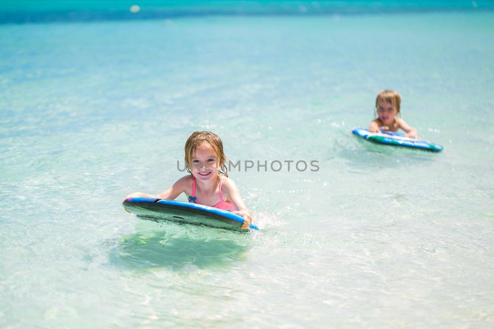 Twins brother and sister to have fun with surfing in the ocean. by StudioPeace