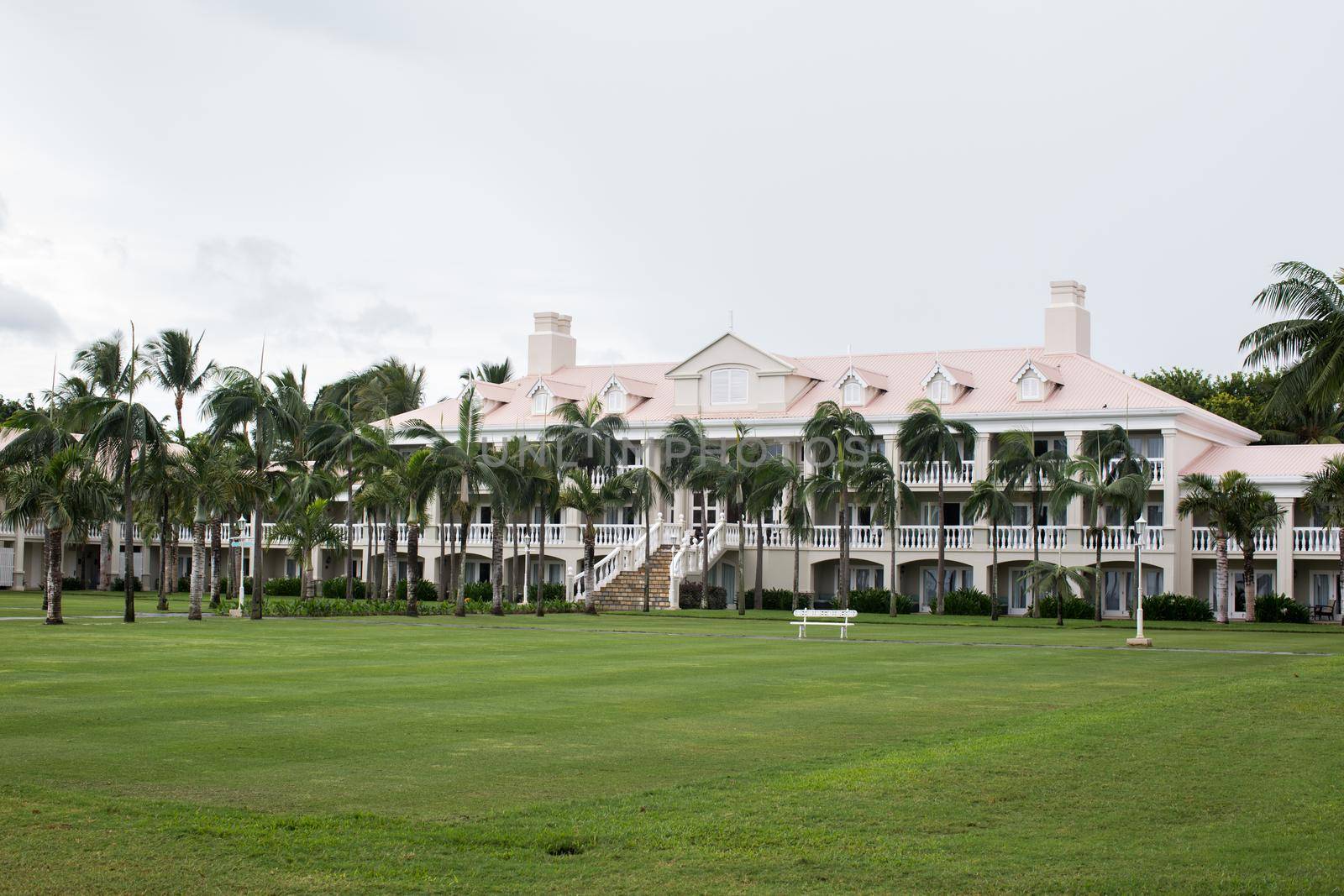 Luxury house in Mauritius, with a green lawn and palm trees.