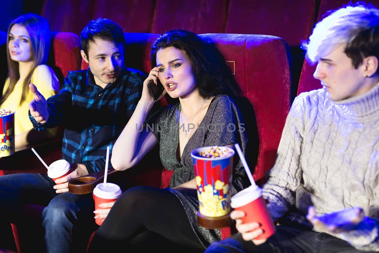 Annoying woman on the phone during movie at the cinema. by StudioPeace