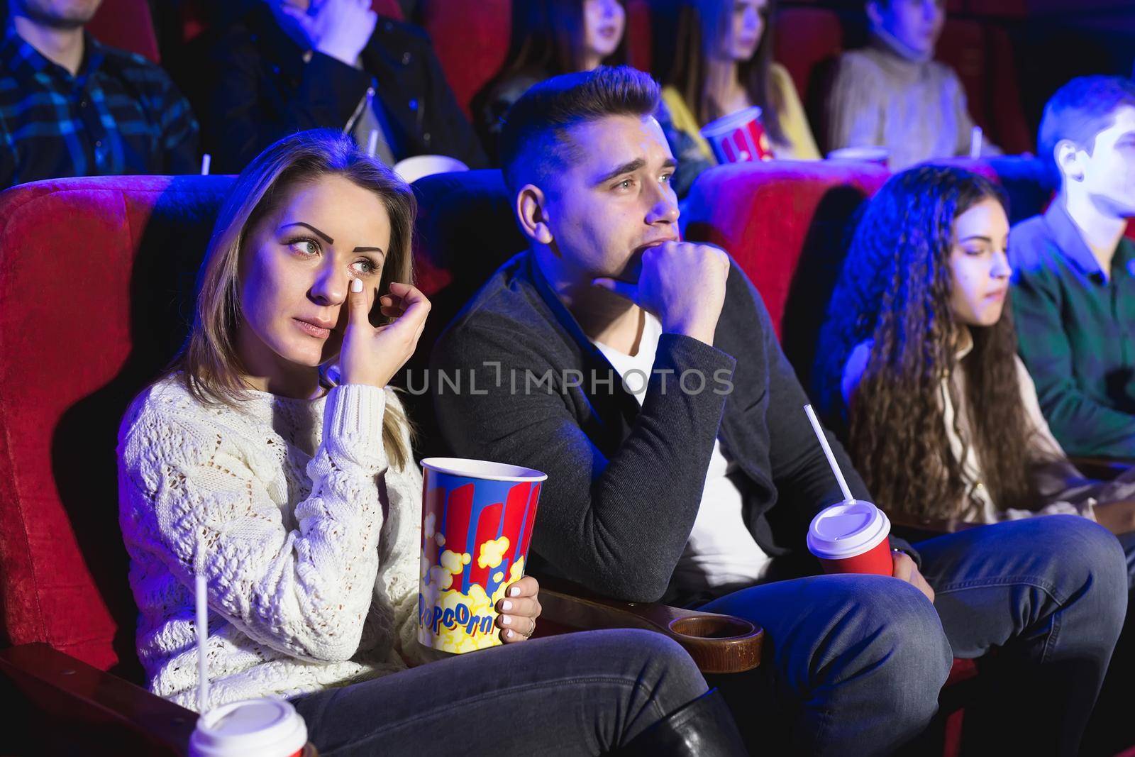 Friends crying watching sad film in the cinema