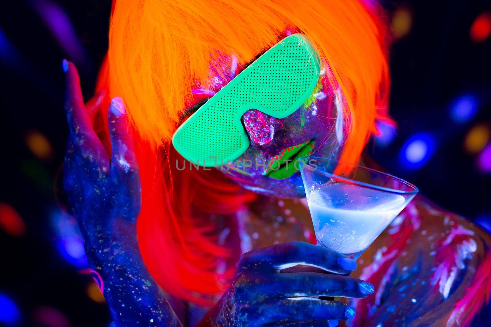 Fashion model woman drinking alcoholic cocktail in neon light, disco night club. Beautiful dancer model girl colorful bright fluorescent make-up. by StudioPeace