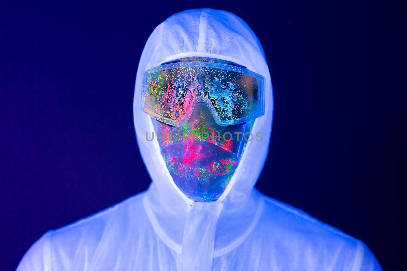 Portrait of man doctor in protective clothes in ultraviolet neon light during coronavirus pandemic. Epidemic, pandemic of coronavirus covid-19