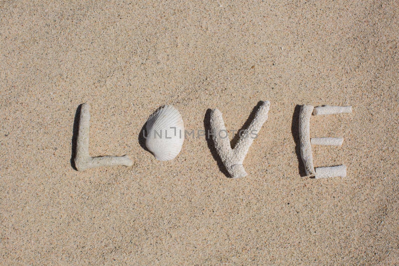 word Love from corals on sand of tropical beach. by StudioPeace