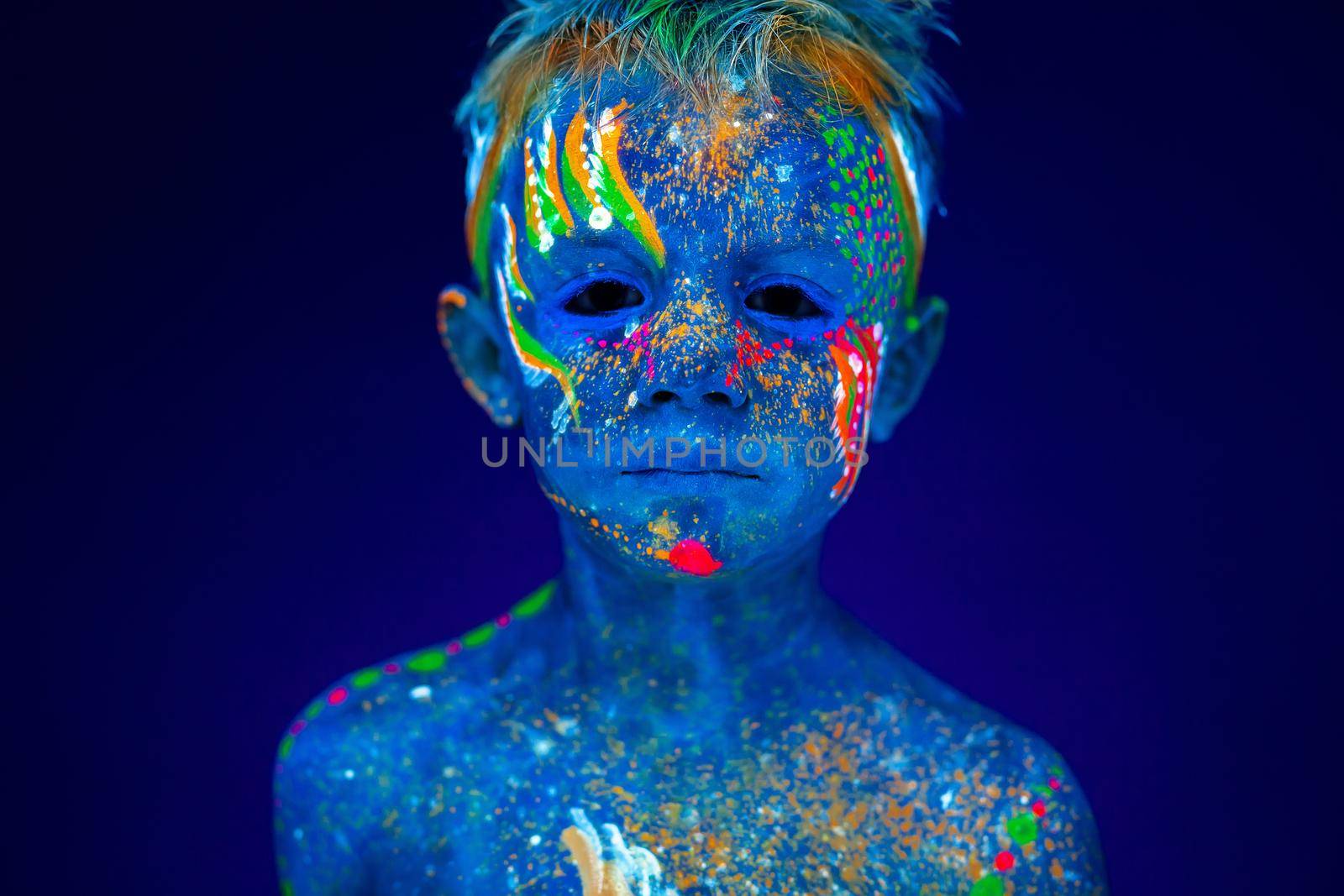 Portrait of a neon child boy posing in UV