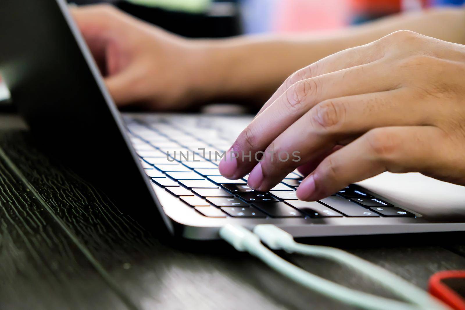 Close-up of hands of businessman typing on laptop keyboard