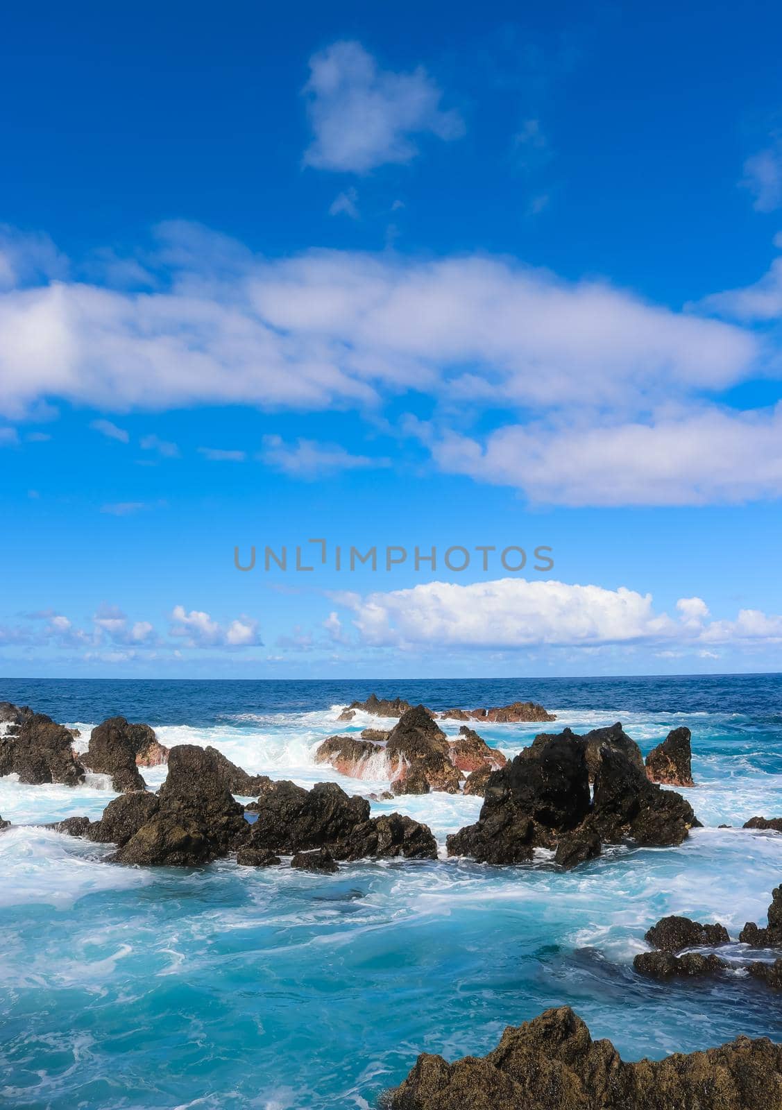 Waves crashing among the rocks of the turquoise water rock pools of the island of Madeira, Portugal. High quality photo.