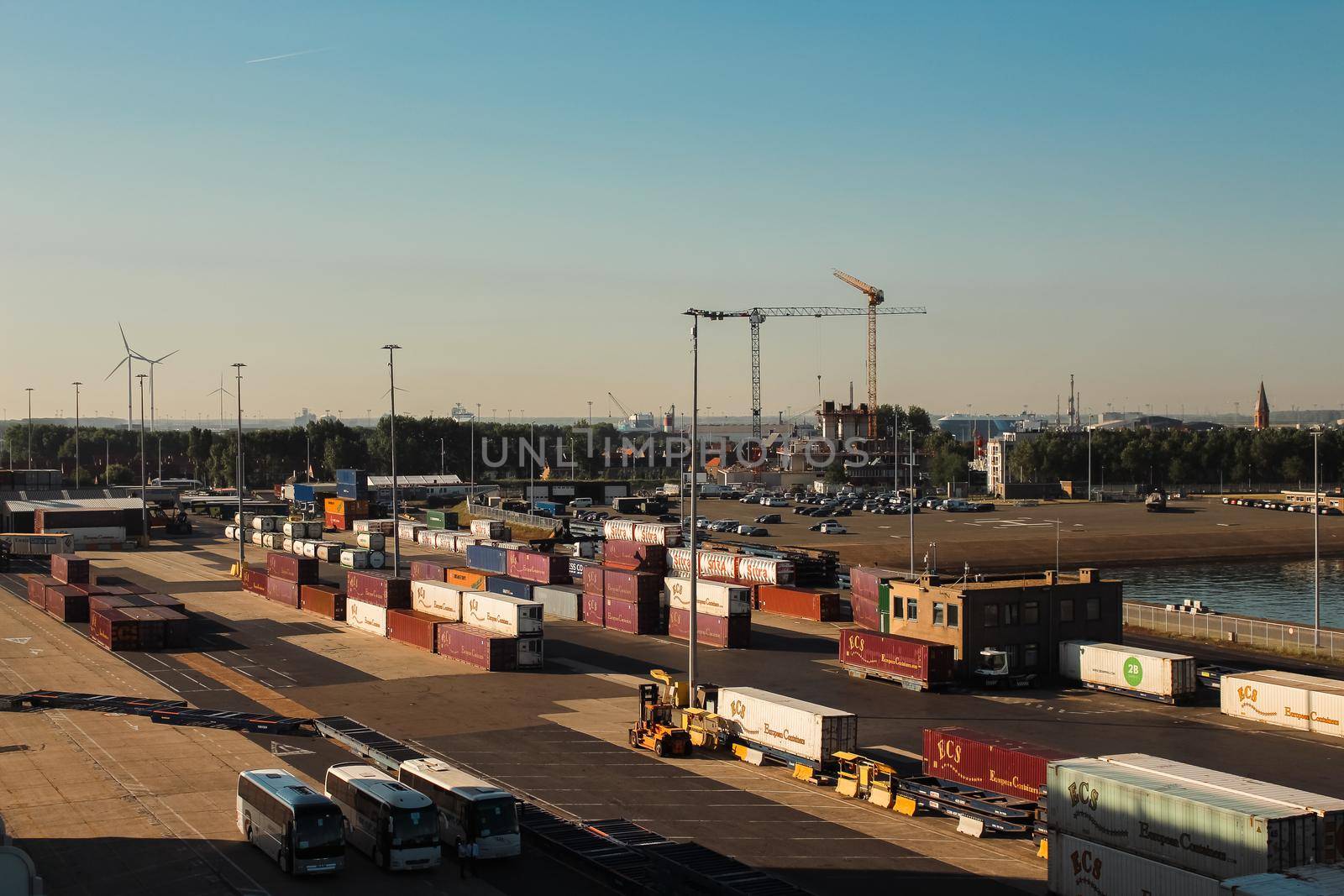 Cargo, cranes, freight and containers in Bruges' port at sunset, Belgium. High quality photo.