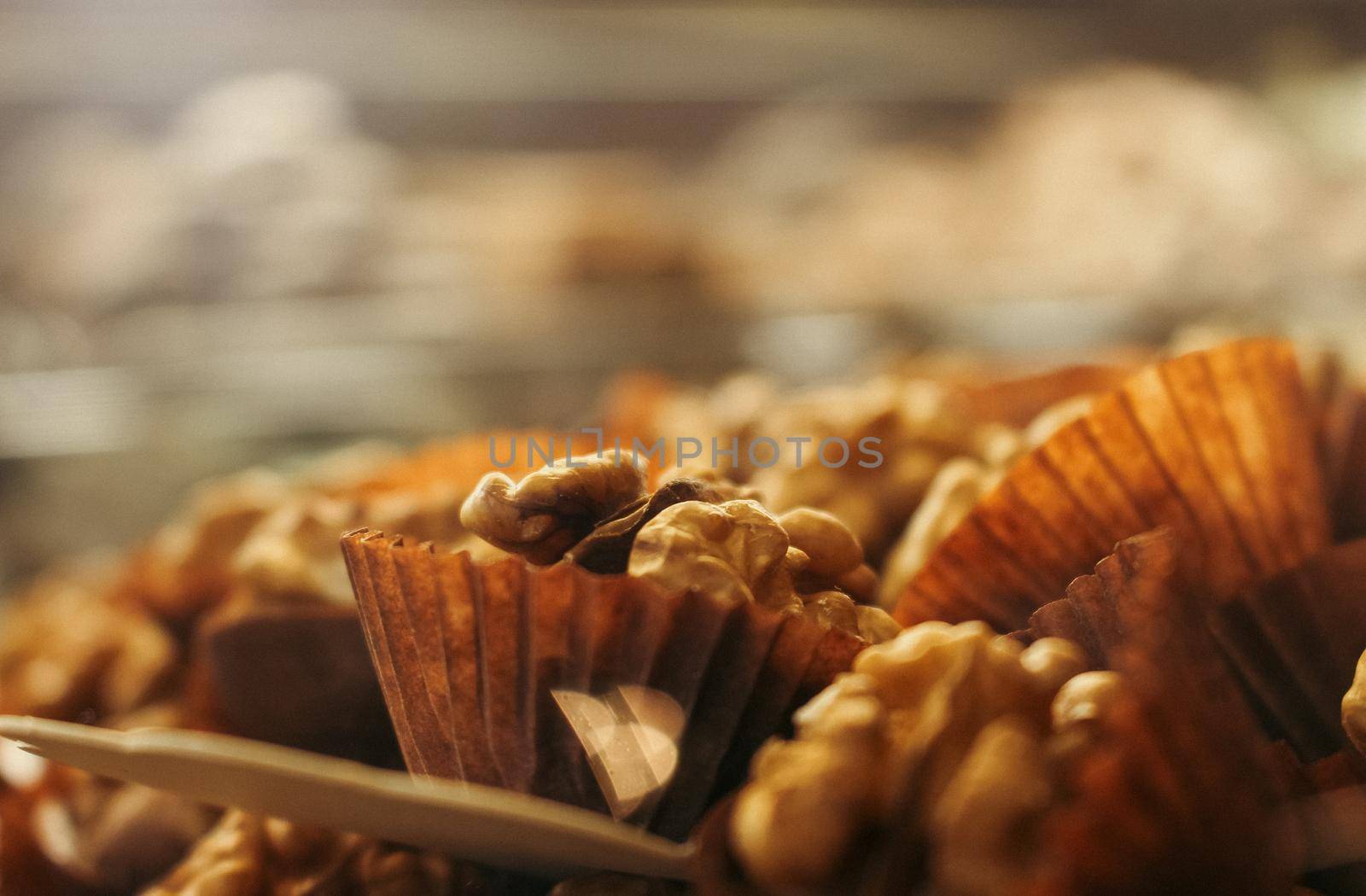 Cased walnut cakes close up, blurred background, on display in a coffee shop, Florence, Italy. High quality photo.