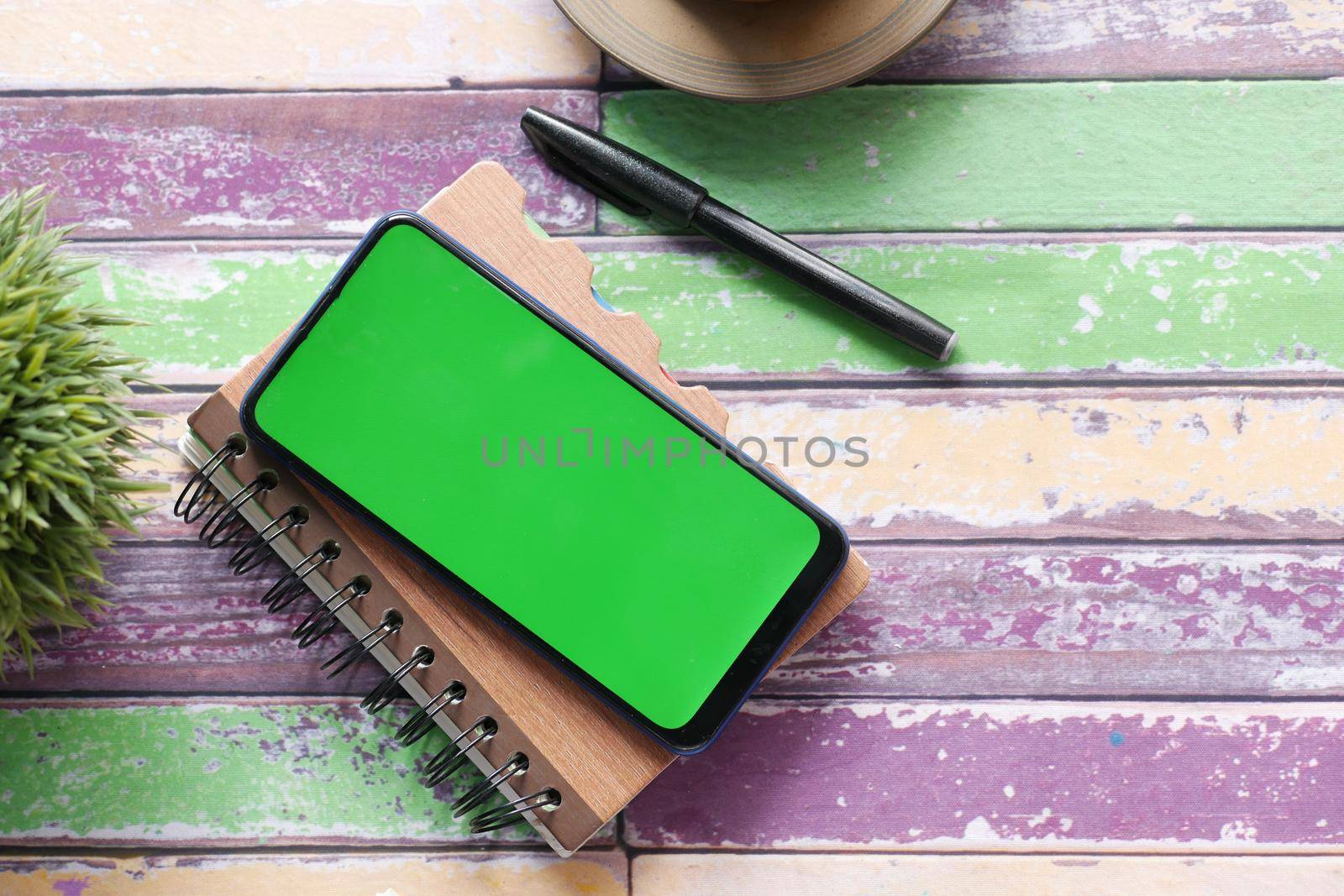 top view of smart phone and notepad on table .