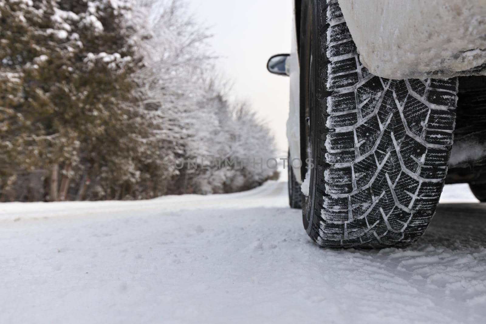 Close up of Winter Tire on Snow and Ice Covered Road by markvandam