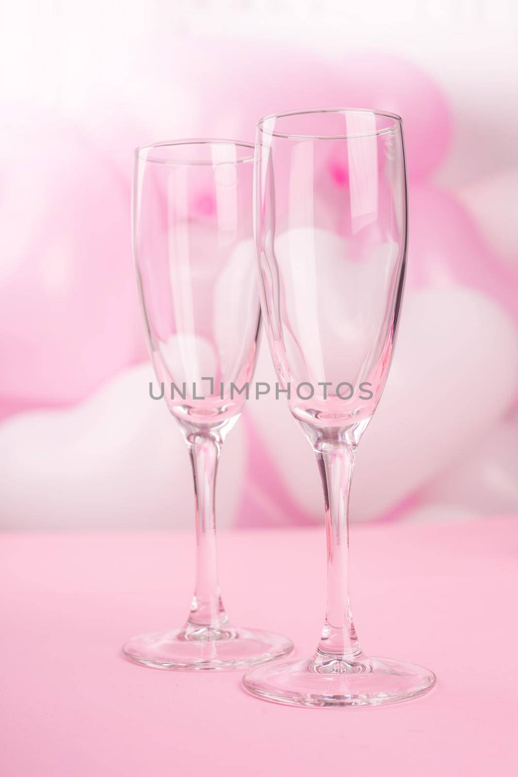 Valentines day champagne flutes glasses on pink balloons background with copy space for text