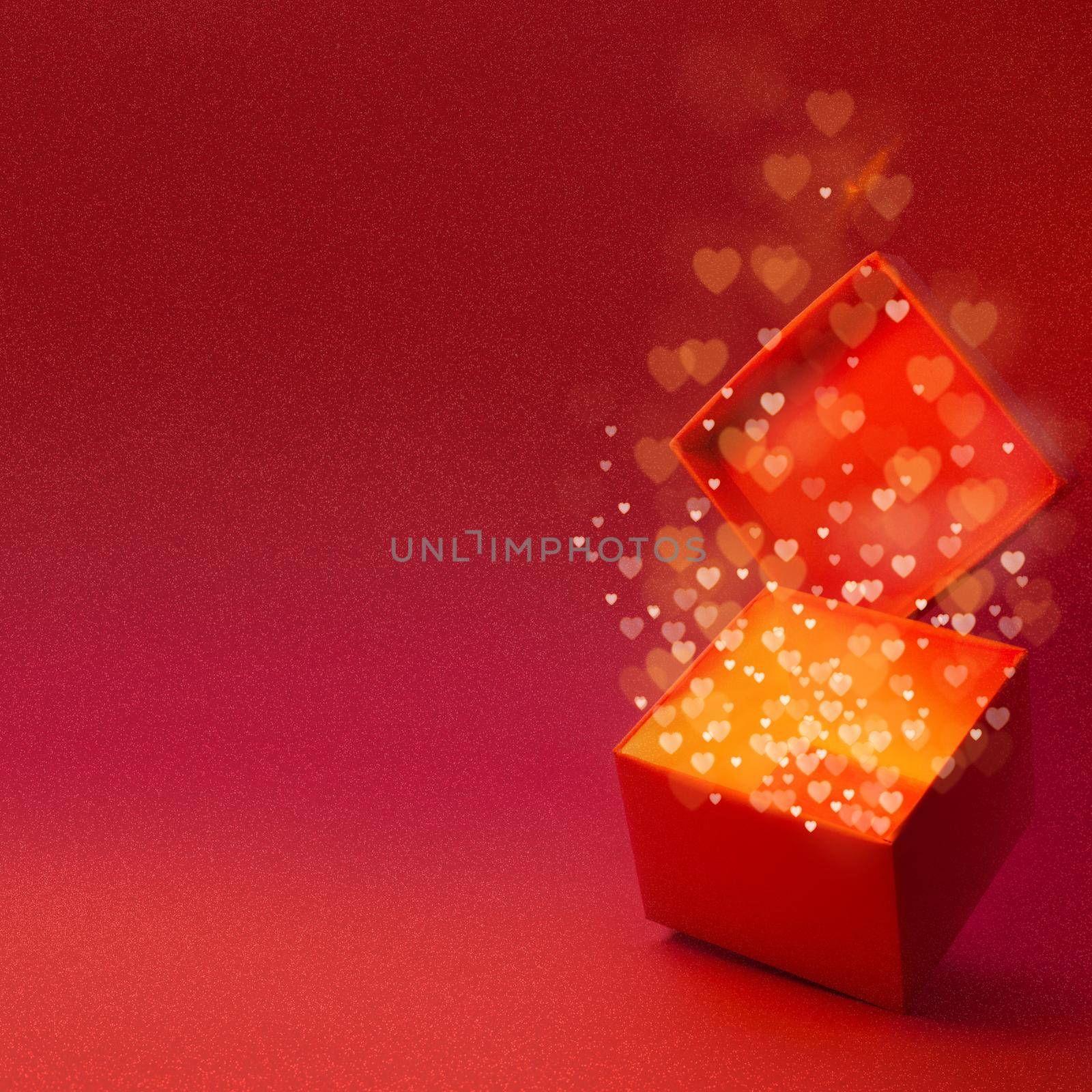 Magic box with love gift for Valentines day, pink red glowing with light from inside with bokeh hearts on glitter background with copy space for text