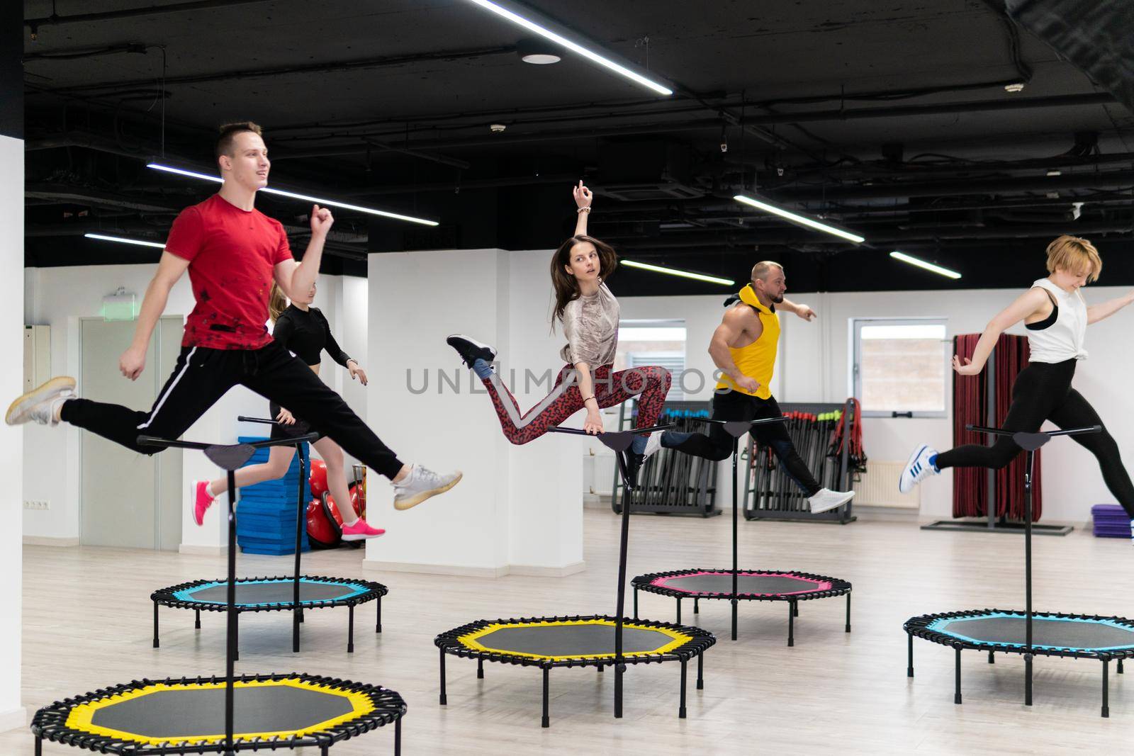 Women's and men's group on a sports trampoline, fitness training, healthy life - a concept trampoline group batut instructor men, for female team for sporty from sport body, shape happiness. Many bodycare indoor, class